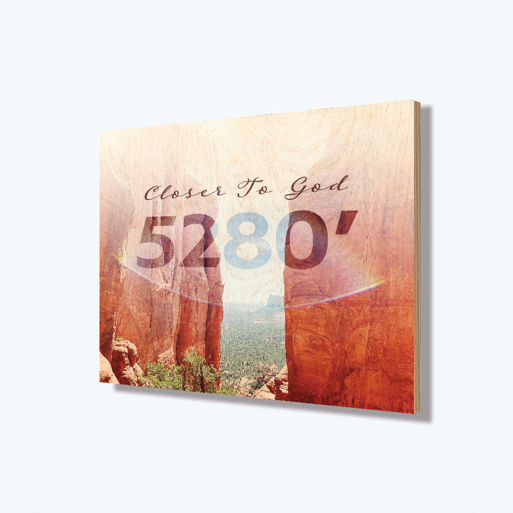A wood poster with red rocks on both sides and Christian text in low opacity at the top of the design.