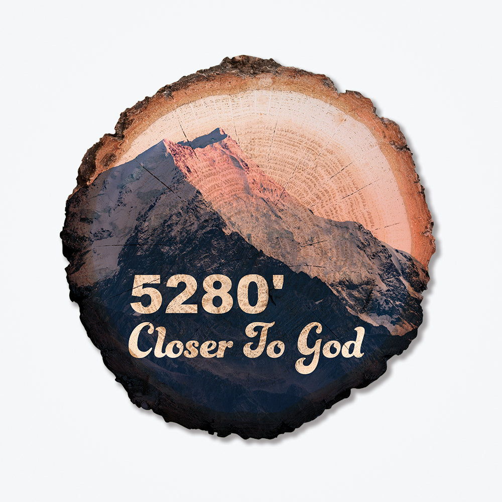 Wood poster with the font Closer to God with a silhouette of a mountain in the background.