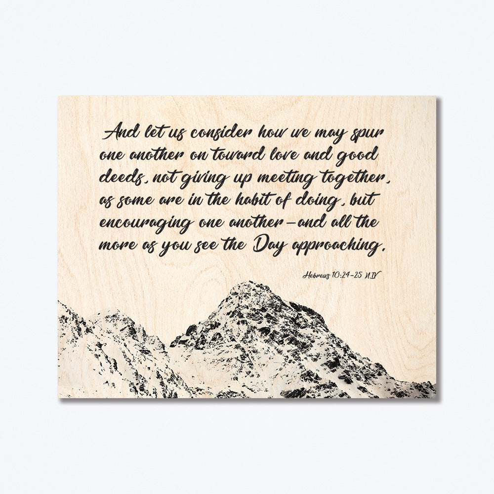 A wood poster with an encouraging message from the bible and a silhouette of a mountain top in the background.