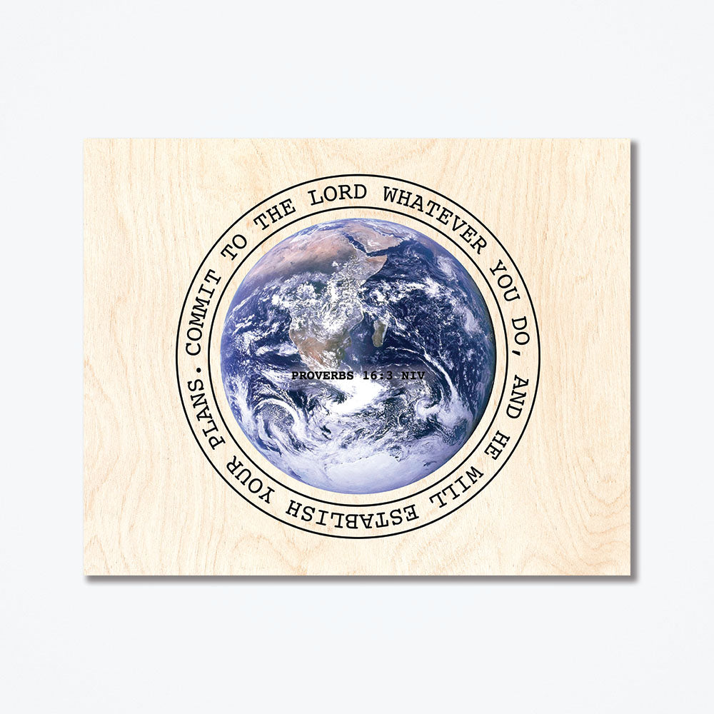 A wood poster with text from Proverbs 16:3 NIV surrounding the Earth.