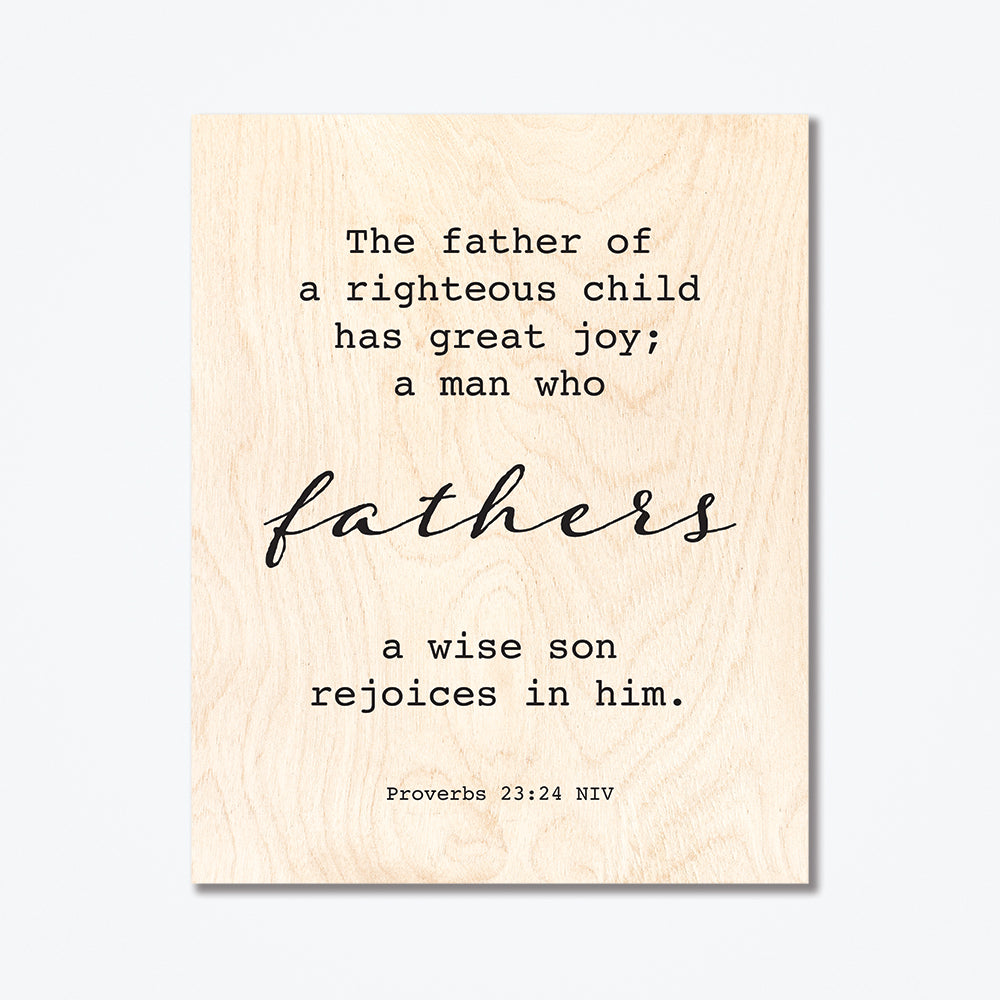 A wood poster with black text from a bible verse from Proverbs.