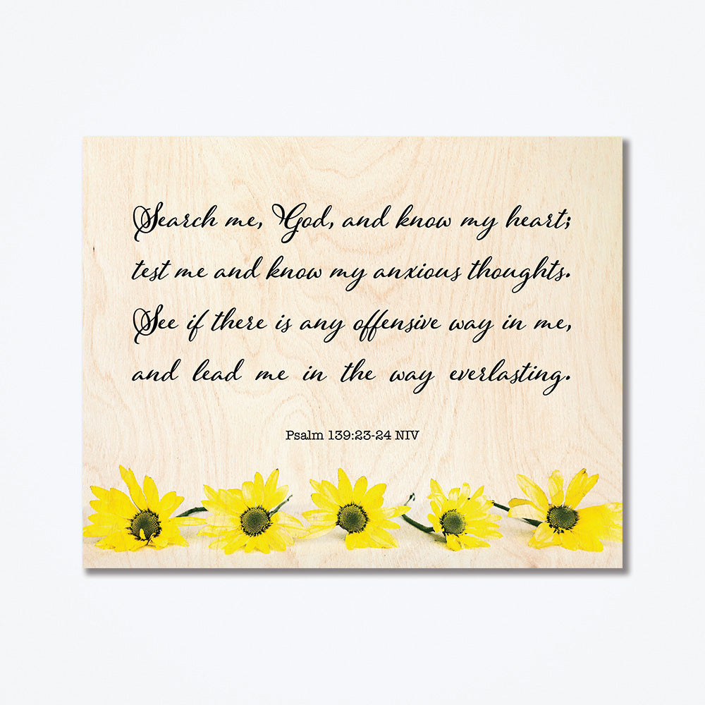 A wood poster with thin cursive text at the top and sunflowers at the bottom.